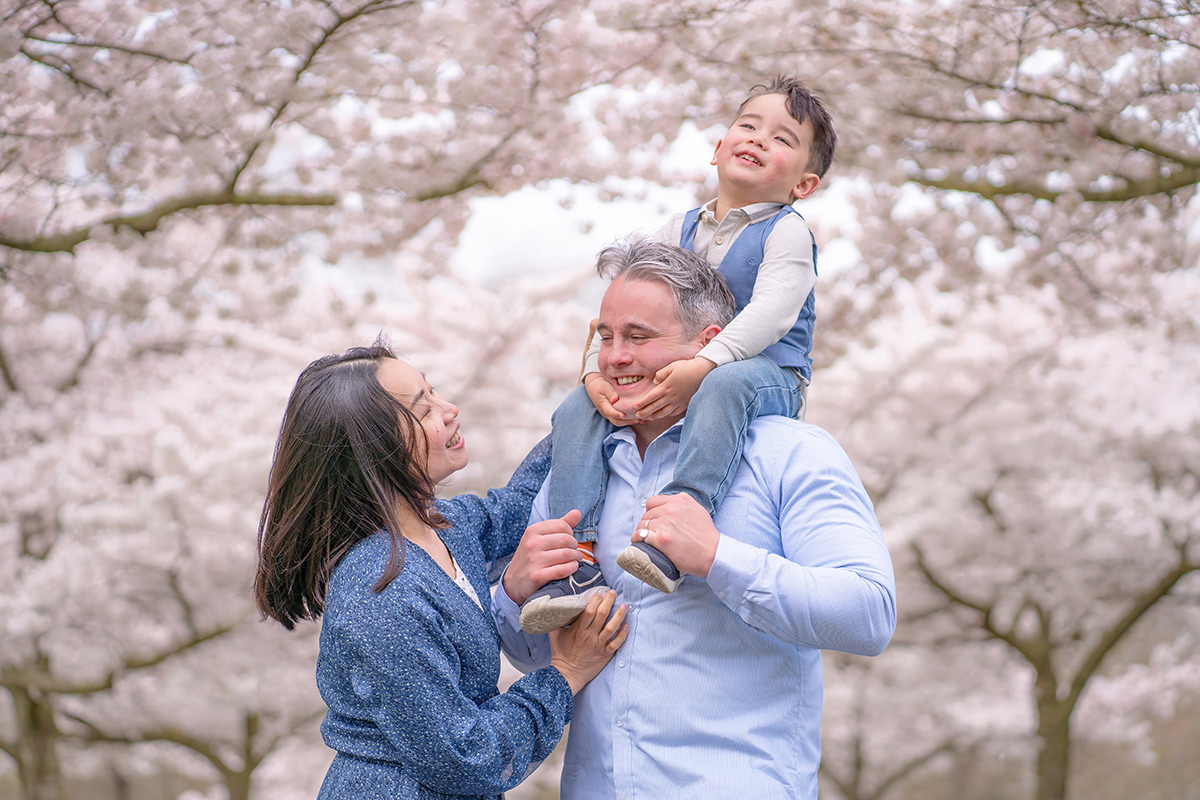 family playing under cherry blossoms in London