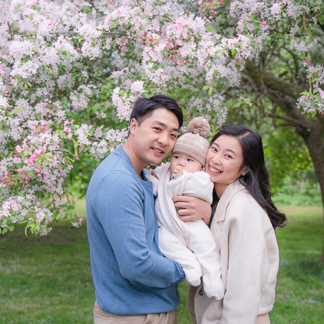 family with baby in front of a blossom tree London